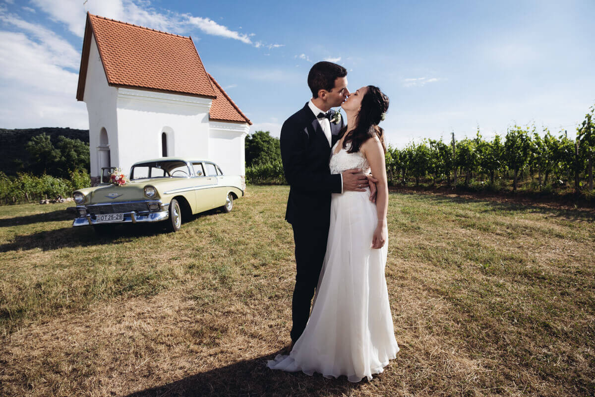 Esküvő fotózás során készült fotó Nóriról és Zoliról, mögöttük az autó.